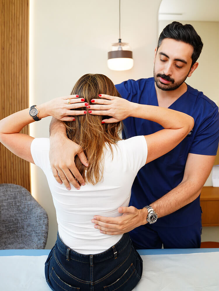 Physiotherapist assisting a woman with posture and back exercises during a therapy session.